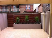 Transformation complete - The finished product of the rear yard which started out as just a lawn but turned into a rear oasis with paving, lighting, irrigation, rendered garden bed, plants and timber slat wall.