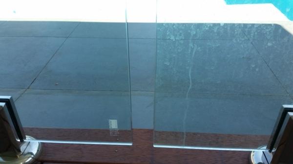 Cleaning Swimming Pool Glass Panels - Before (right panel) After (left panel)